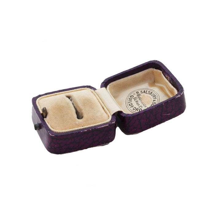 an opened up ring box purple exterior cream interior